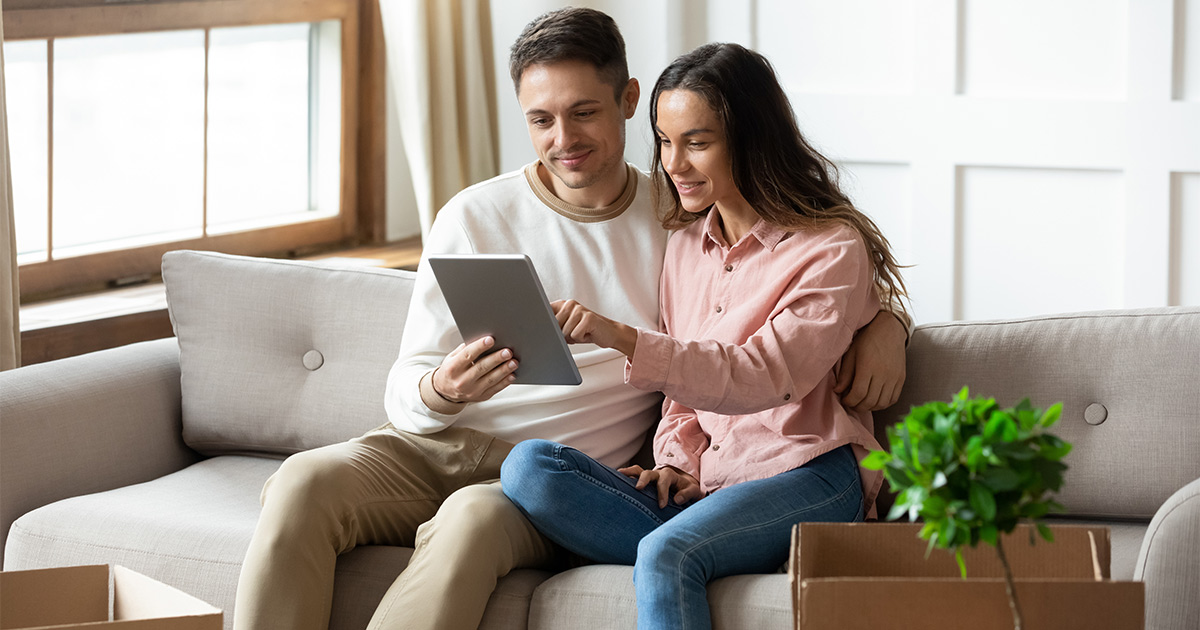 A couple review a moving checklist on a tablet; it was provided to them by their mortgage banker as a long distance moving resource.