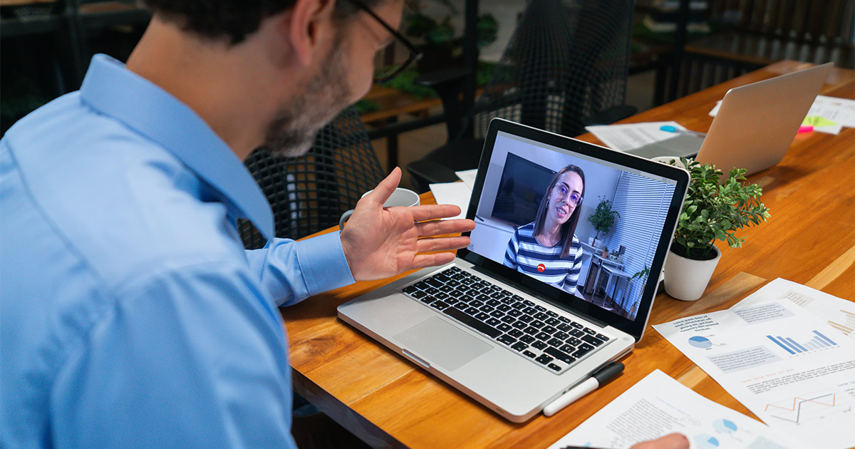 A mortgage banker discusses housing trends with his client on a video call. 